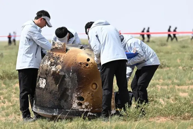 Technicians inspect the Chang’e-6 return capsule at the recovery site.