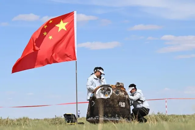 The returned Chang’e-6 capsule and recovery team beneath the Chinese flag.