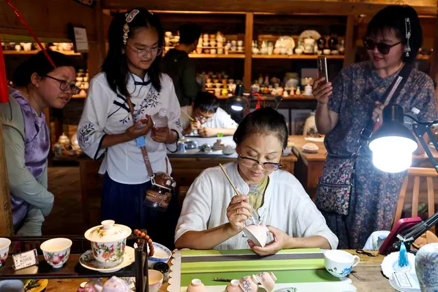 An artisan works on a ceramic piece in Jingdezhen, 13 July 2025.