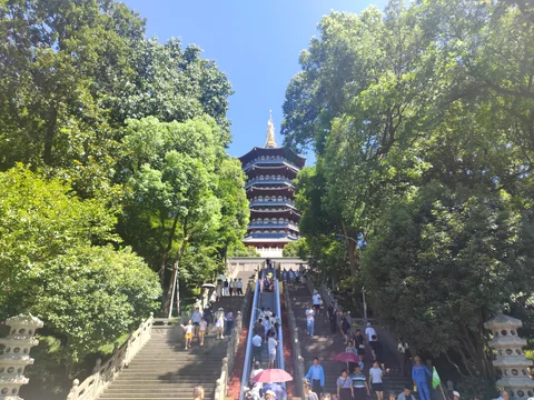 Leifeng Pagoda above a tree-lined stairway in Hangzhou.
