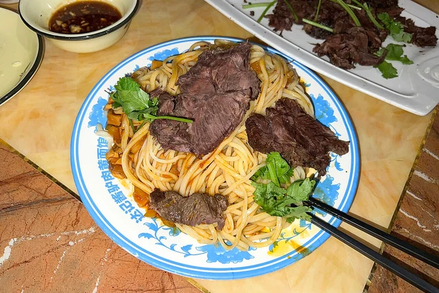 Donkey meat mixed with yellow noodles, photographed in Dunhuang in 2023.