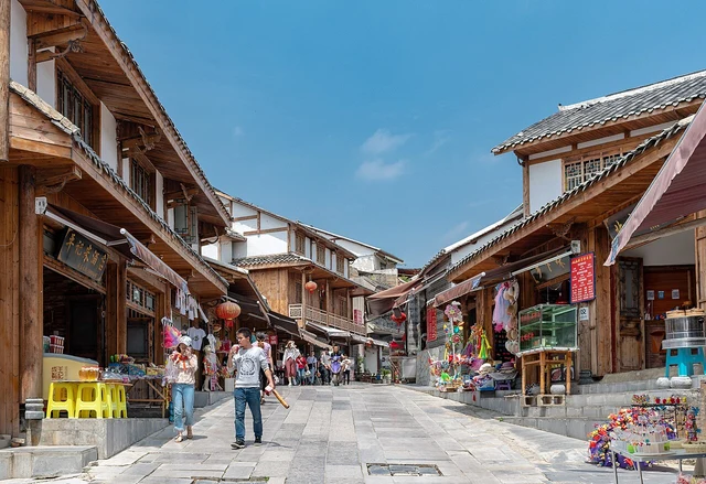 A Qingyan street with stone paving and shop fronts, photographed in June 2018.