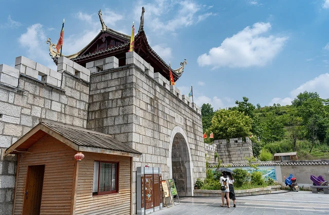 Stone walls and an arched opening in Qingyan’s gate area; a historical photograph without a claim that every stone is original.