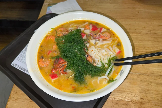 Zaopocu seafood rice-noodle soup at a Sanya restaurant, photographed in March 2023; one regional serving variation.