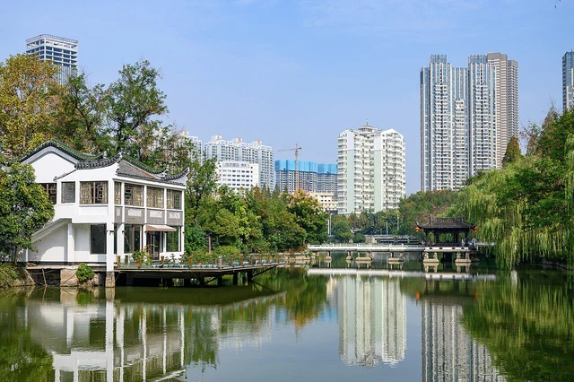 Waterside architecture and gardens in Hefei’s Bao Park in a historical photograph; distinguish memorial spaces from Northern Song material evidence.