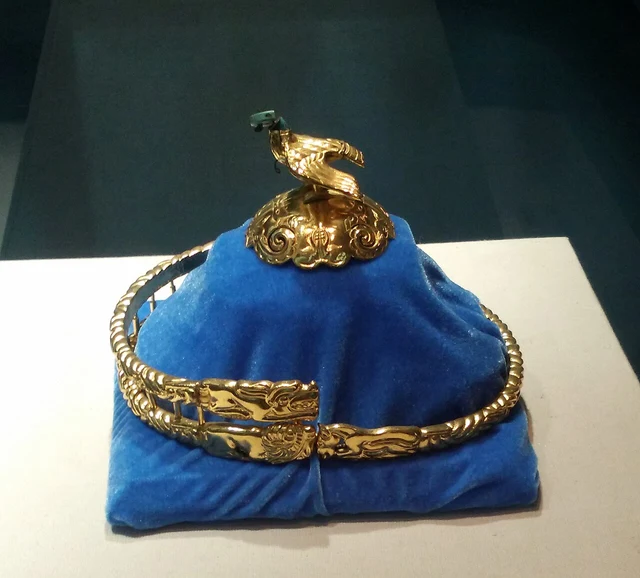 A historical display photograph of the eagle-topped gold crown in the Inner Mongolia Museum collection; verify today’s gallery position and original or replica status.