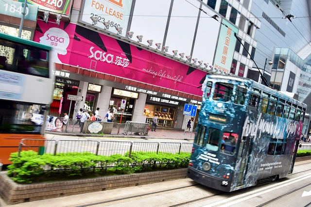 A double-decker Hong Kong tram on a city street.