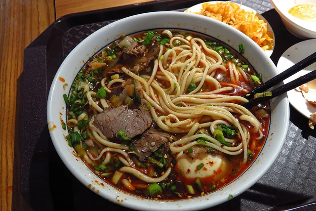 Beef noodle soup and separate accompaniments photographed in Anning, Lanzhou.