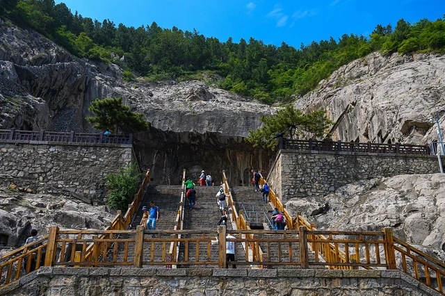 Exterior cliff niches and visitor stairs at Longmen Grottoes, Luoyang.