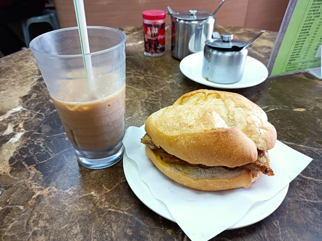 A pork-chop bun served with milk tea.