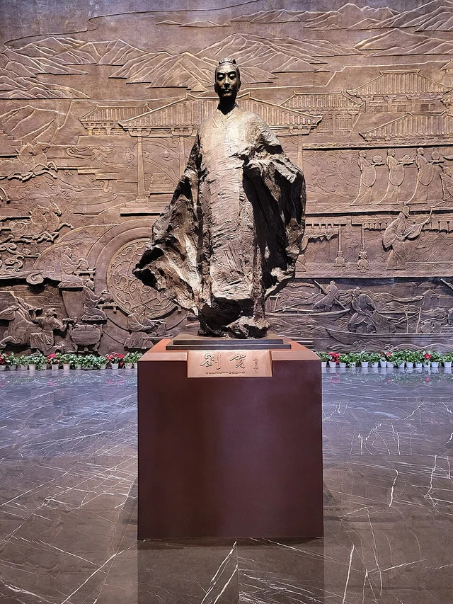A photograph of a modern Liu He sculpture inside the Haihunhou site museum, not an excavated Han portrait.
