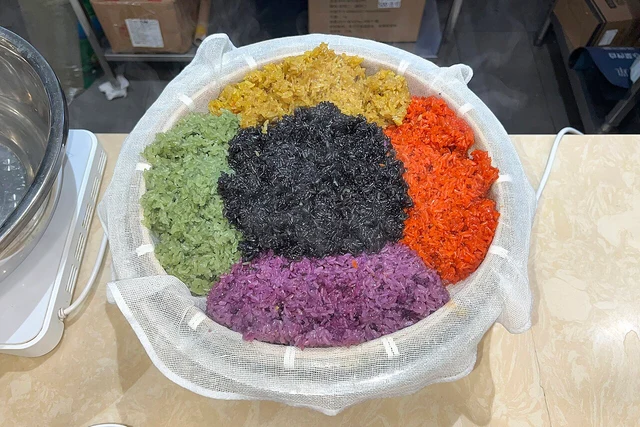 A five-coloured glutinous rice variation, including green rice, at a Guangxi-style restaurant in Beijing; a regional dish example.