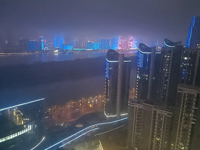 Illuminated buildings beside the Xiang River in Changsha at night in March 2025.