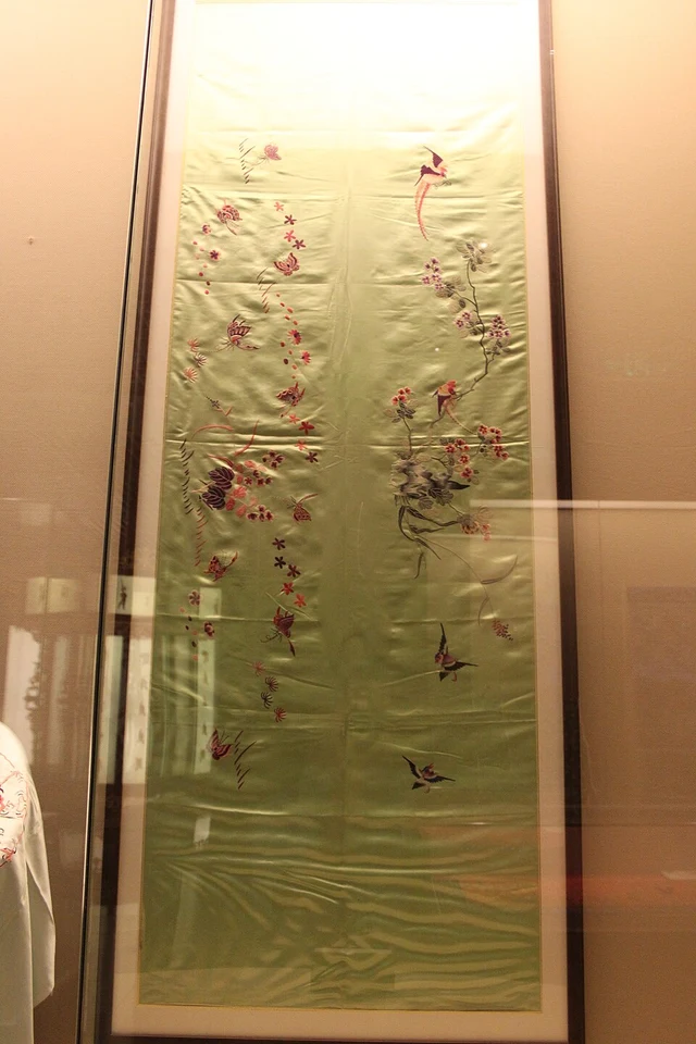 A floral Sichuan embroidery panel displayed in the Sichuan Provincial Museum.