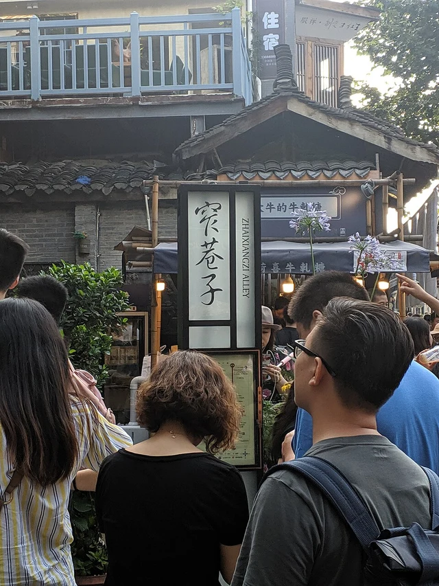 Visitors beneath the Kuan Alley entrance sign in Chengdu in July 2019.