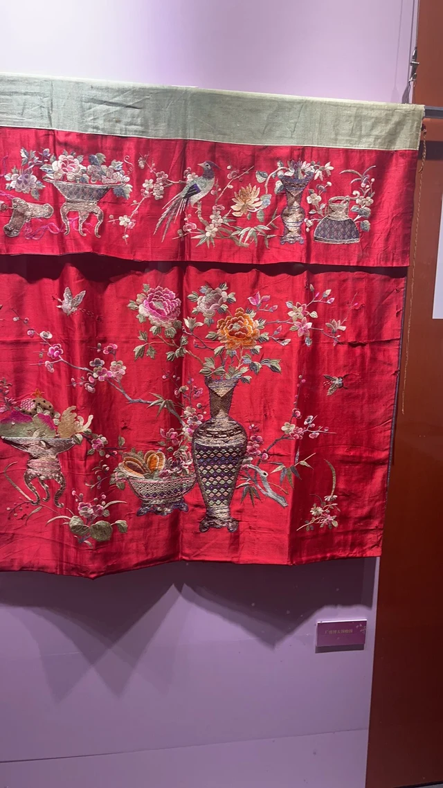 A red Cantonese embroidery piece displayed at Nanhai Museum.