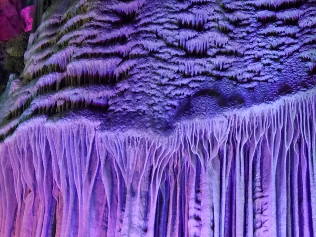 Curtain-like limestone formations lit inside Silver Cave near Yangshuo.