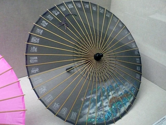 A Hangzhou silk umbrella with painted decoration, displayed open.