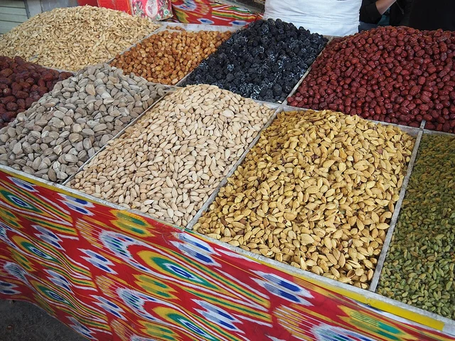 Dried fruit and nuts displayed in separate trays at Kashgar bazaar.