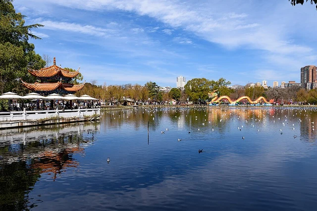 Cuihu Park's lake, pavilion and a seasonal dragon decoration in Kunming in February 2024.