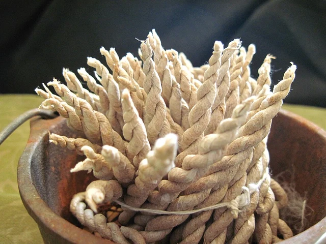 Twisted Tibetan rope incense arranged in a small cast-iron vessel.