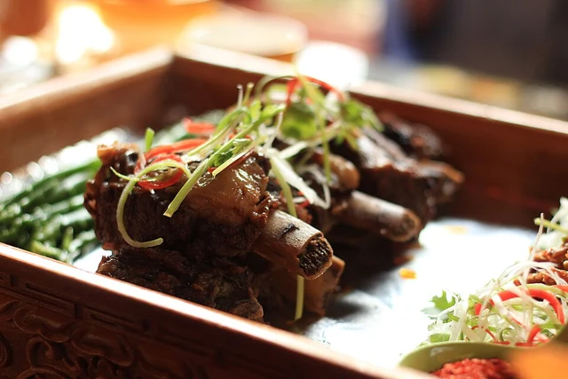 A Tibetan yak-meat dish with garnish in a wooden serving tray.