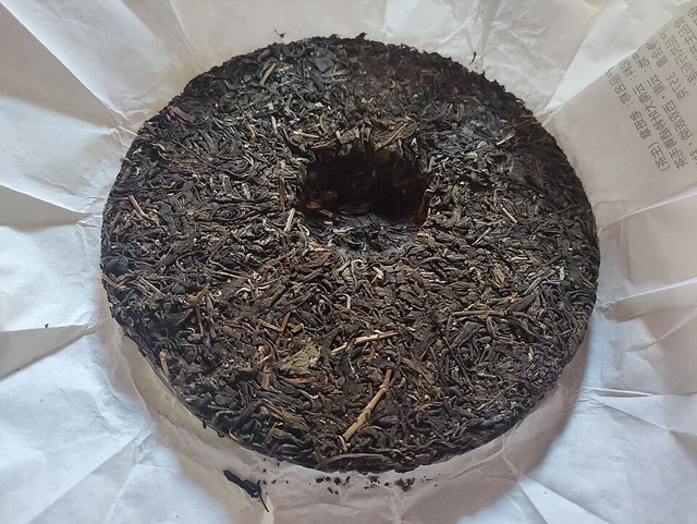 A compressed Pu’er tea cake on its paper wrapper.