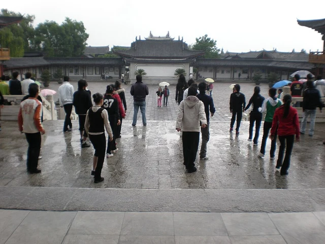 Visitors in a stone-paved courtyard of Mu Mansion in Lijiang.