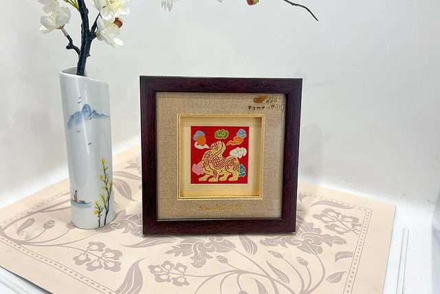 A framed Nanjing Yunjin brocade with a Bixie motif displayed on a train in June 2026.