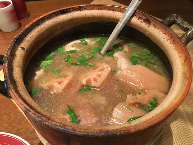 Lotus-root pieces and pork bones in a clay pot of soup.