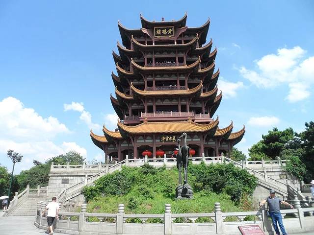 The Yellow Crane Tower in Wuhan, seen in full with visitors beneath a blue sky.