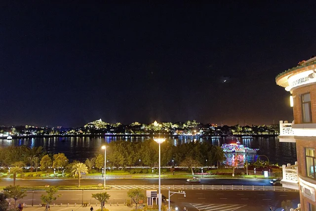 Gulangyu's illuminated shoreline seen across the water from Xiamen at night.
