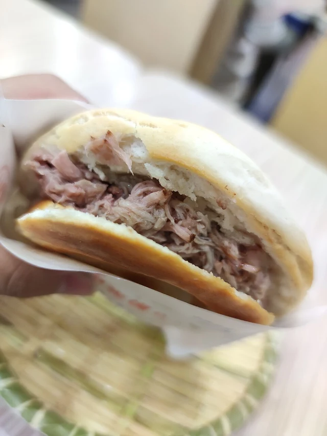 A hand-held roujiamo with chopped pork filling from Xi'an's Jixiang Village area.