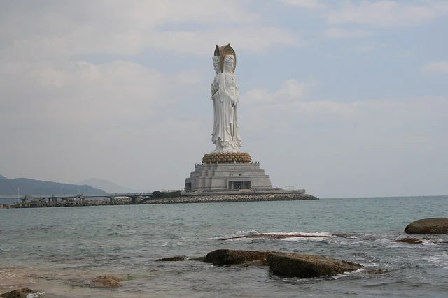 The complete Guanyin figure and pedestal beside the sea at Nanshan in Sanya; a historical photograph.