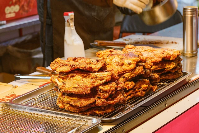 Vinegar-splashed fried chicken frames sold on Xita Street, Shenyang, photographed in March 2026; one shop preparation.