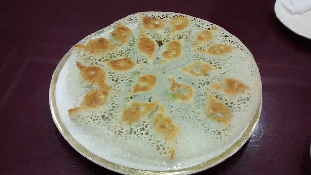 Lacy-crust pan-fried dumplings at Laobian in Shenyang, as identified by the photographer; an individual preparation.