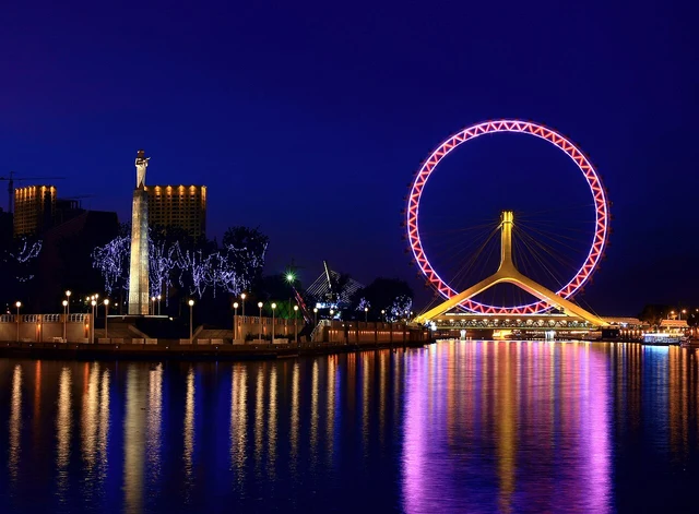 The Tianjin Eye and Hai River at night; historic lighting does not establish current operations.