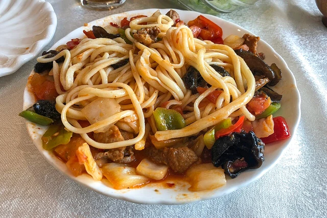 Xinjiang-style sautéed beef mixed noodles, photographed in Beijing as a dish example.