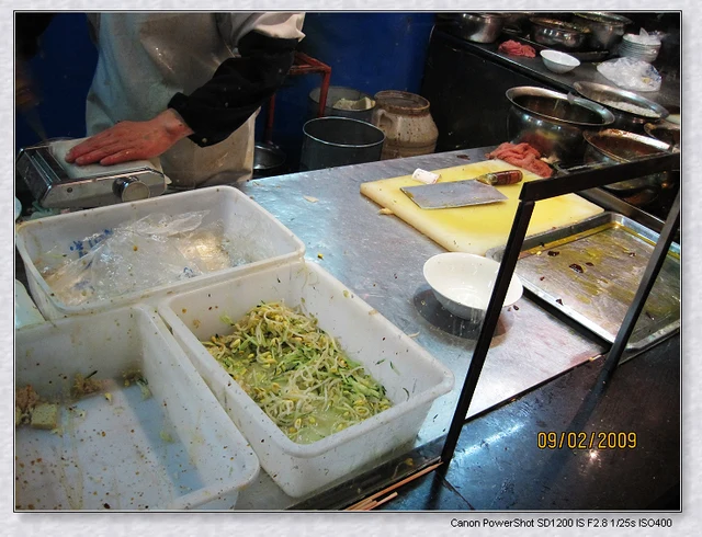 A niangpi stall and preparation counter on Mojia Street, Xining, photographed in 2009; this shows the stall rather than a plated serving.