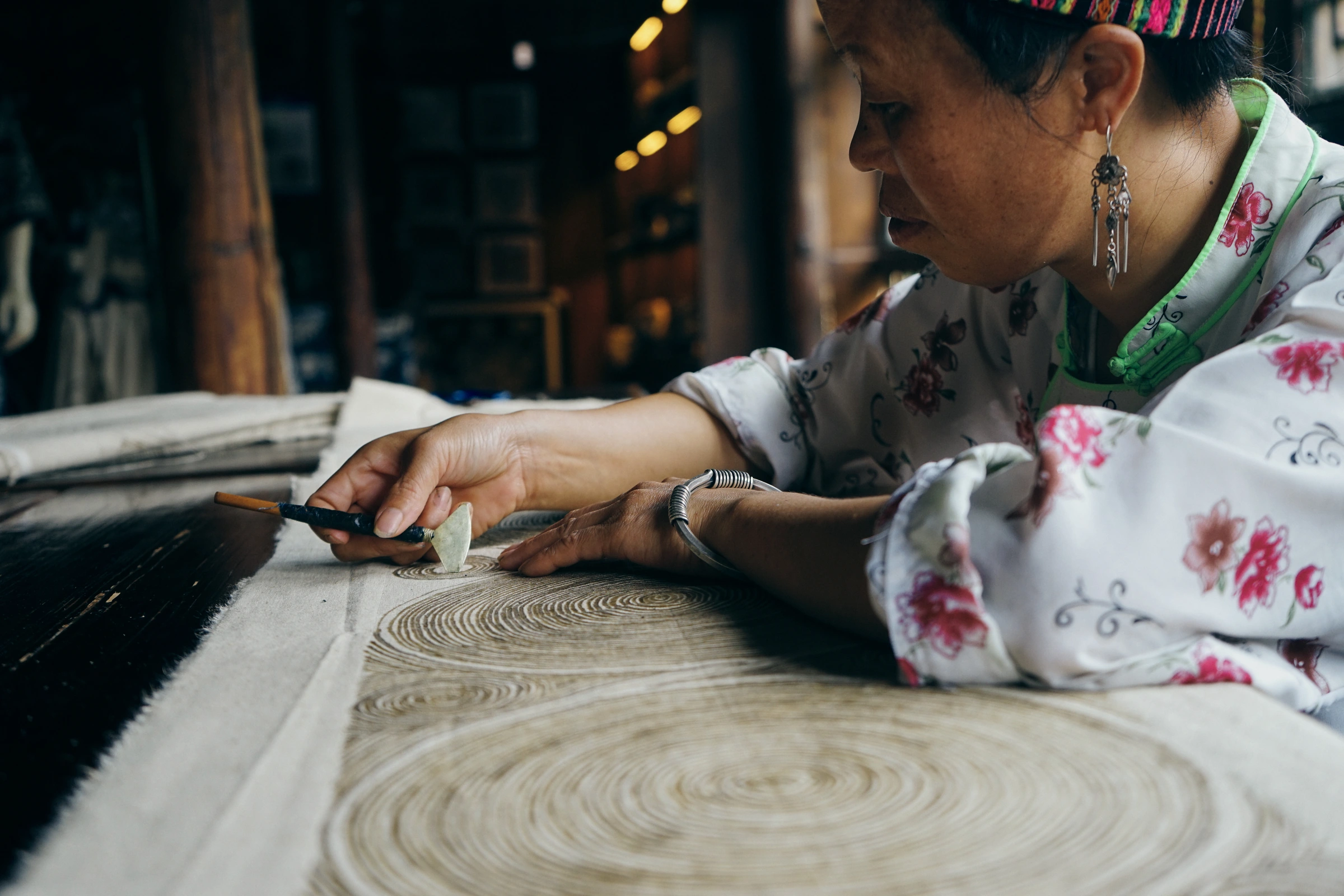 An artisan draws intricate wax-resist patterns onto a Miao batik textile in Guizhou.