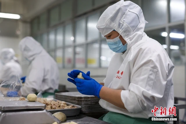 A worker shaping handmade pastry dough at Beijing Daoxiangcun's Changping food factory in November 2024.