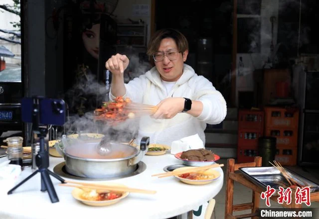 Bamboo chuan-chuan skewers lifted from a steaming pot in Chengdu, shown as a regional dish reference.