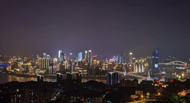 Chongqing's illuminated skyline at night viewed from Nanshan One Tree viewpoint.