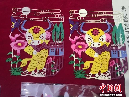 Two coloured Guangling papercut works depicting buffalo and flowers.