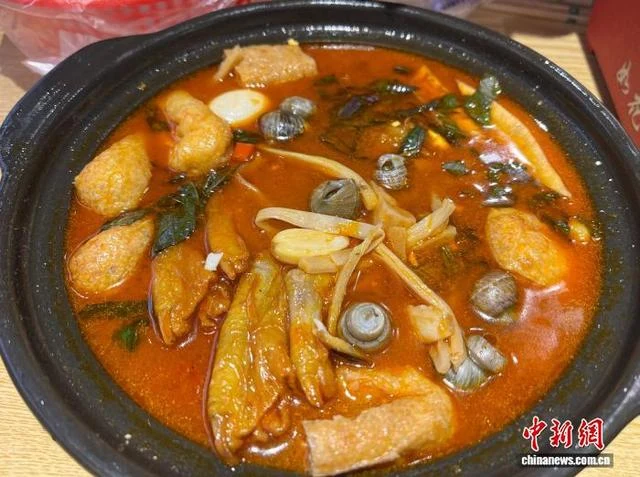 A clay pot of Guangxi duck-feet and snail hotpot photographed in Liuzhou.