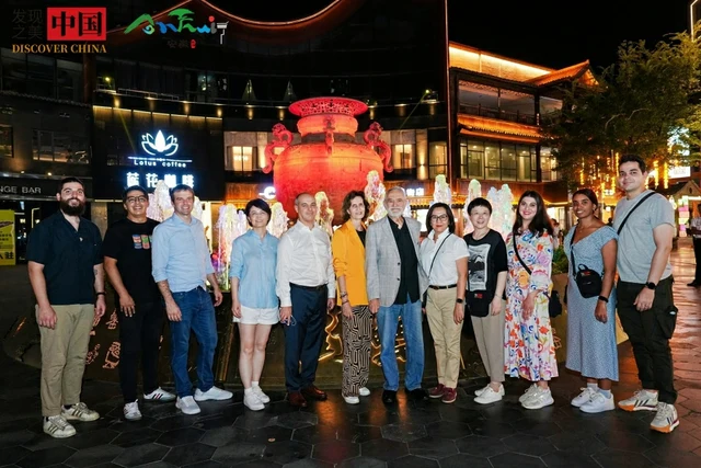 Diplomats visiting Hefei Lei Street on 8 September 2024 pose in front of an illuminated red lei sculpture; Chinaculture.org supplied photograph.