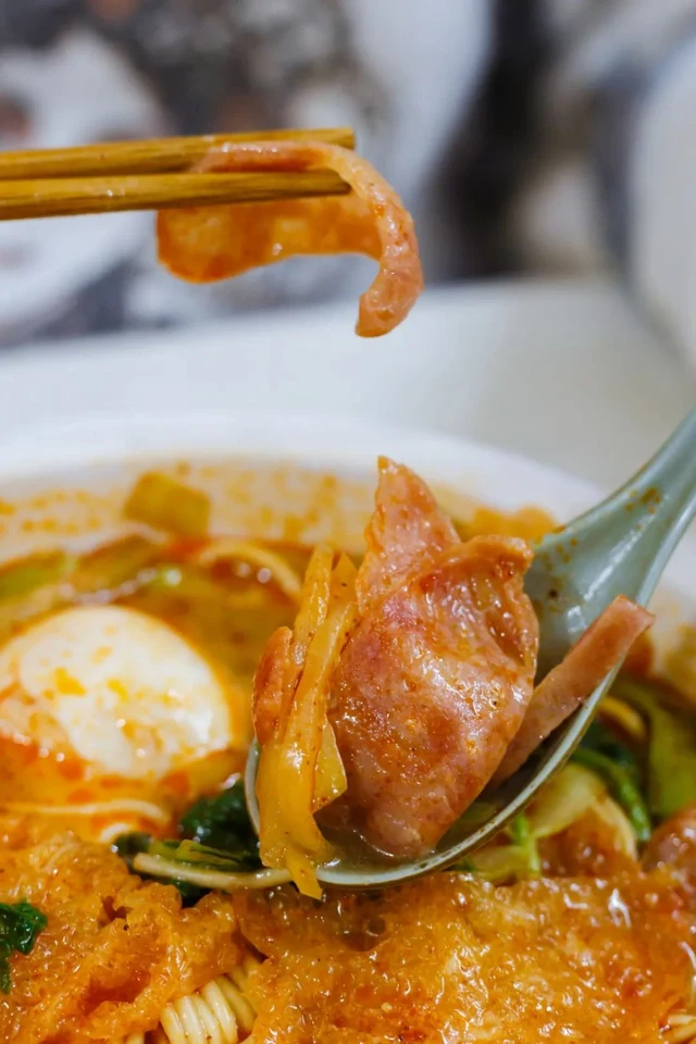 Puffed pork skin lifted from a bowl of Nanjing pidu noodles.