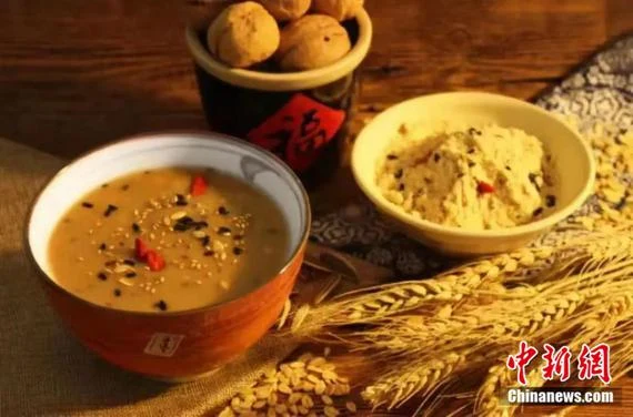 Pingyao oil tea in a bowl beside roasted flour and pastries, supplied by the Pingyao Culture and Tourism Bureau in 2025; original China News watermark retained.