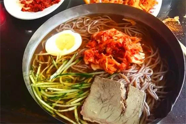 Xita-style cold noodles in a chilled metal bowl, illustrated by Liaoning’s official English portal in November 2019.