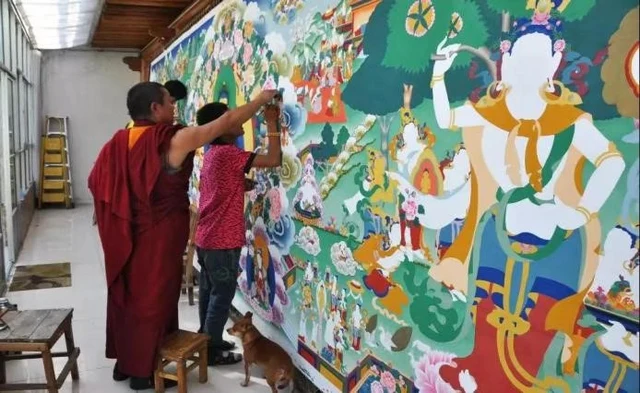 Artists working on the large wall mural Life of Shakyamuni at Kumbum Monastery, in a historical photograph supplied by Yinba Jiancuo for The Paper’s 2024 interview.